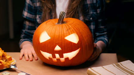 Woman carving Jack O Lantern pumpkin for Halloweenの写真素材