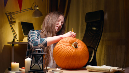 Woman carving Jack O Lantern pumpkin for Halloweenの写真素材