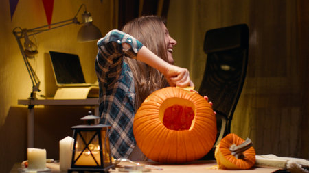 Woman carving Jack O Lantern pumpkin for Halloweenの写真素材