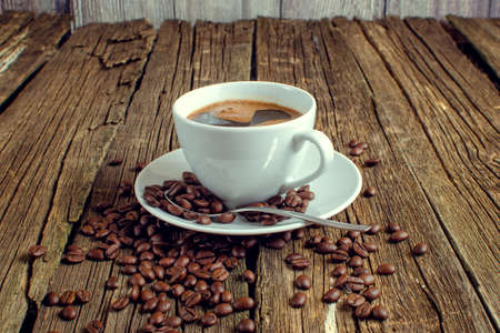 White coffee cup and coffee beans on old wooden background.の写真素材