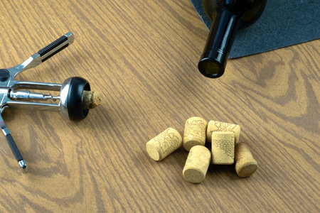 Bottle of wine and corkscrew over wooden background