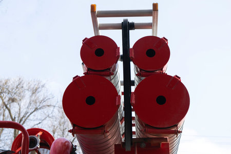 a fire truck, rear view of canisters for transporting suction hoses with fire escapes attached to...