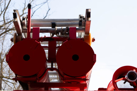 a fire truck, rear view of canisters for transporting suction hoses with fire escapes attached to...