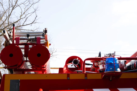 a fire truck, rear view of canisters for transporting suction hoses with fire escapes attached to...