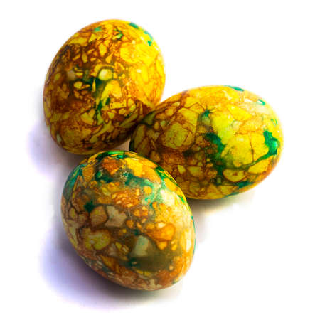 Traditions. handmade yellow green easter eggs painted marbled over white backgroundの写真素材