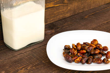 Hushaf - date milk, a traditional dish to Ramadan, cooking, ingredients, dates in the plate and milk in bottles are on the tableの写真素材