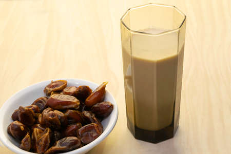 Hushaf - date milk, traditional Ramadan dish, cooking, ingredients, glass with date milk - khushaf and dish with dates are on the tableの写真素材