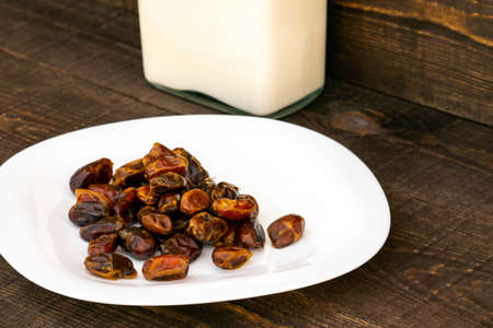Hushaf - date milk, a traditional dish to Ramadan, cooking, ingredients, dates in the plate and milk in bottles are on the tableの写真素材