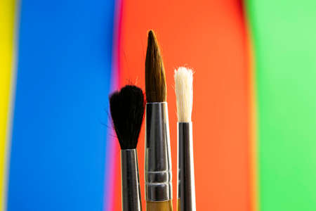 paint brushes on color blurred red-blue-green-yellow backgroundの写真素材
