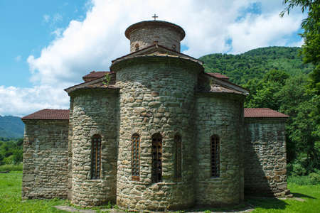 10th century ancient Christian church, Nizhnearhizy temples, Northern Zelenchuk temple, ancient stone temple among mountains and vegetationの写真素材