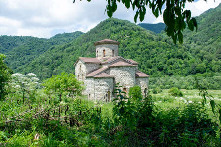 10th century ancient Christian church, Nizhnearhizy temples, Middle Zelenchuksky temple, ancient stone temple among mountains and vegetationの写真素材