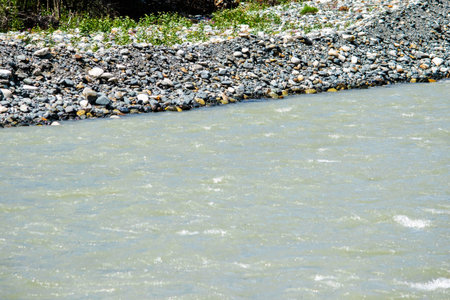 the water of a stormy mountain river flowing among stones and bouldersの写真素材