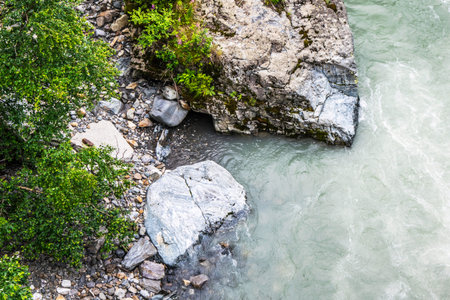 the water of the stormy mountain river flowing among stones and boulders
