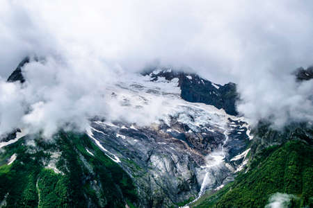 The mountain landscape - mountains forest, rocks glaciers snow clouds, Dombay, Karachay-Cherkessia, Russiaの写真素材