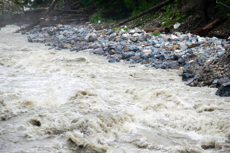 the water of a stormy mountain river flowing among stones and boulders
