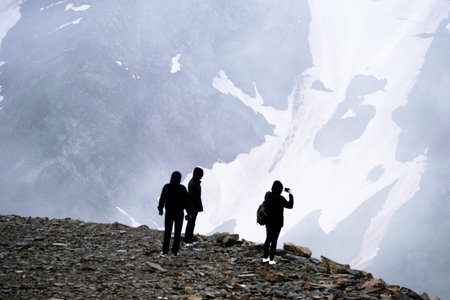 tourists stand over a precipice high in the mountainsの写真素材