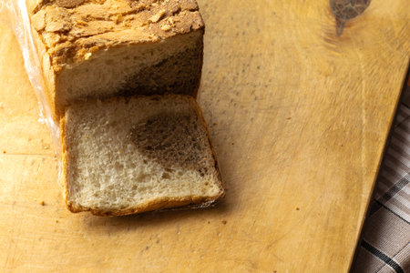 sliced bread with a separated slice lies on a cutting wooden board