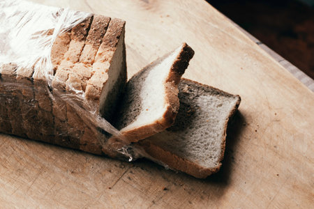 sliced bread with a separated slice lies on a cutting wooden board