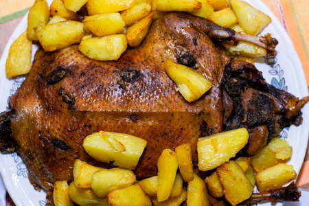 oven-baked golden-crusted duck with potatoes lies on a dishの写真素材