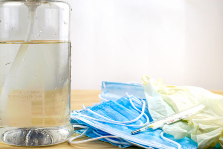 medical protective hygiene masks, rubber gloves, thermometer and a sanitizer in a transparent bottle...
