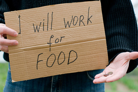 the unemployed person holds in his hand a cardboard tablet with the inscription i will work for food in his other hand the remaining coinsの写真素材
