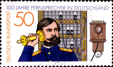 02 08 2020 Divnoe Stavropol Territory Russia Germany postage stamp 1977 The 100th Anniversary of the Telphone German telephone centenary: Telephone Operator and Switchboardのeditorial素材