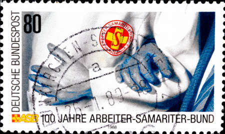 02 11 2020 Divnoe Stavropol Territory Russia postage stamp Germany 1988 The 100th Anniversary of the First-aid Association Linked Arms Samaritan Workers' Associationのeditorial素材