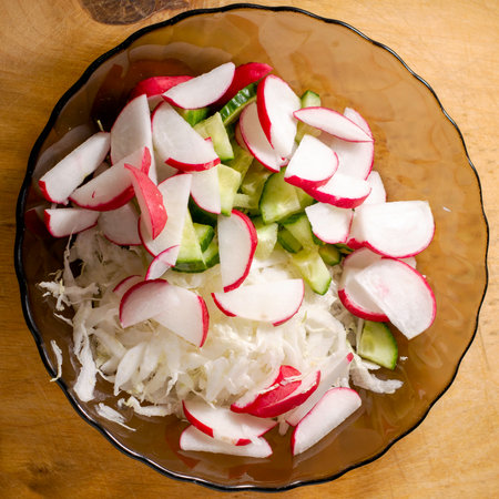 vegetable salad of cabbage radish and cucumbers on a glass plate. High quality photoの写真素材