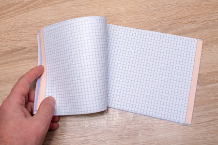 a person opens a notebook lying on the table a place for writing