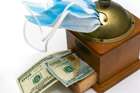 the concept of earning money on a pandemic in a manual coffee grinder medical masks are ground and...
