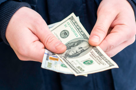 a man holds two hundred-dollar bills in his hands close-up. High quality photo