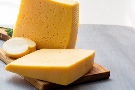 pieces of cheese on a wooden cutting board. High quality photo