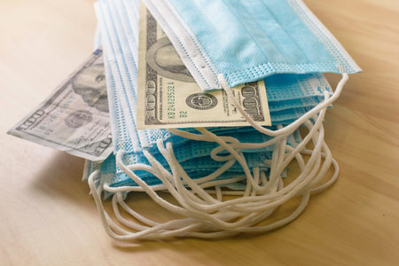 the concept of virus and business a stack of medical masks lies on the table among the masks are...
