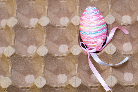 Easter egg decorated with a satin ribbon in the egg stand.