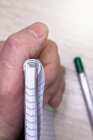 a man holds a gray notebook in his hand. High quality photo