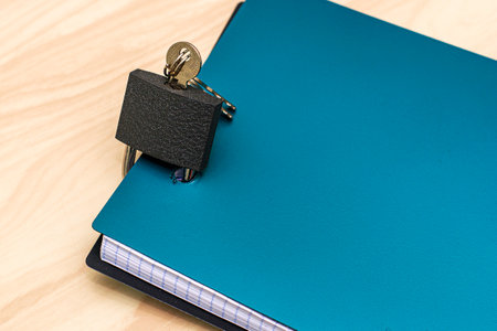the concept of information protection a closed lock with keys hangs on the notebook for notesの写真素材