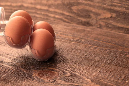 chicken eggs in a stand on a wooden table. High quality photo