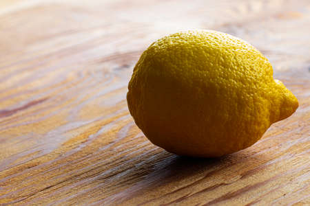 one yellow lemon on the wooden surface of the table. High quality photoの写真素材