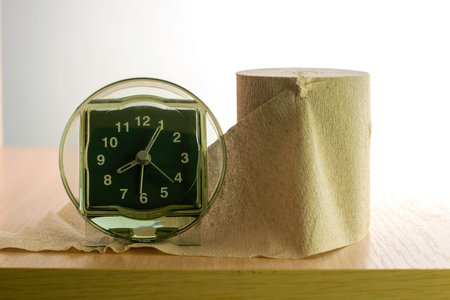 a roll of toilet paper and a clock on the shelf concept daily routine proper nutrition. High quality photoの写真素材