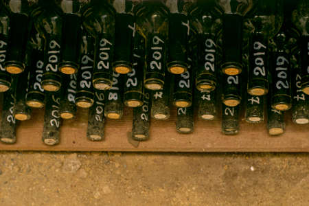 bottles of dry red wine stacked on a shelf in the wine cellar. High quality photoの写真素材