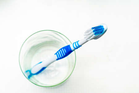 a toothbrush in a glass cup on the bathroom table top view. High quality photoの写真素材