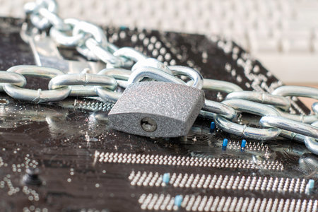 the computer motherboard is wrapped with an iron chain the lock on the chain is closed the concept...