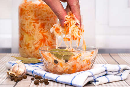 a man eats sauerkraut with his hands from a glass cup. High quality photoの写真素材