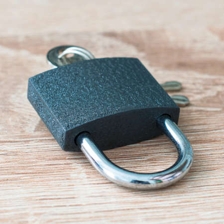 iron padlock with keys in the keyhole on a wooden surface concept prohibition security restriction. High quality photoの写真素材