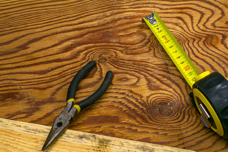 measuring tape measure board and pliers on the workbench. High quality photo