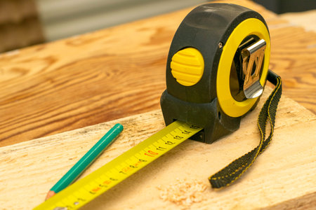 unfolded measuring tape on a wooden board. High quality photo