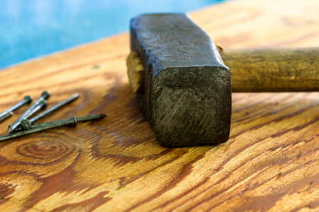a large iron hammer and nails on a wooden surface. High quality photoの写真素材
