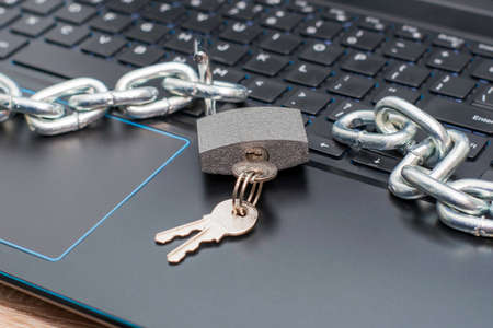 open hinged iron lock with keys and an iron chain on the laptop keyboard concept information protection internet censorship. High quality photoの写真素材