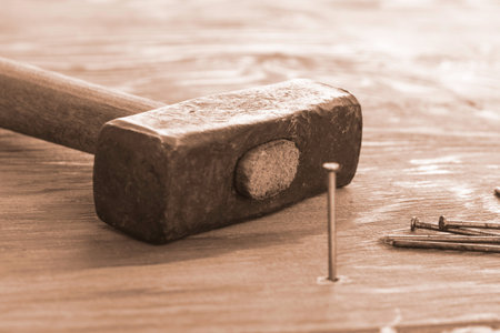 hammer and nails on the wooden surface one nail is hammered into the board. High quality photo
