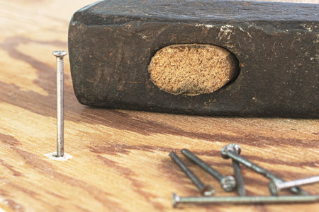 hammer and nails on the wooden surface one nail is hammered into the board. High quality photo